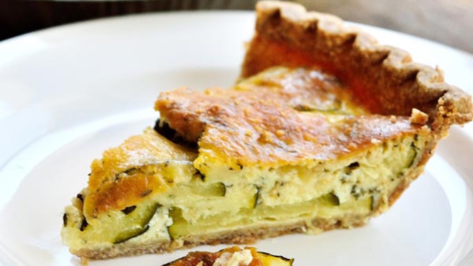 A slice of zucchini pie on a white plate.