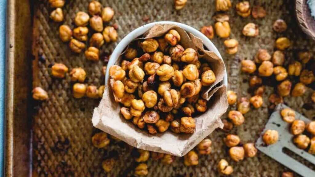 An overhead view of a small, white bowl filled with cinnamon toast crunch roasted chickpeas.