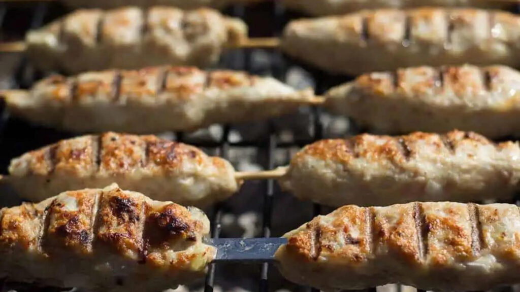 Ground chicken skewers on a grill.