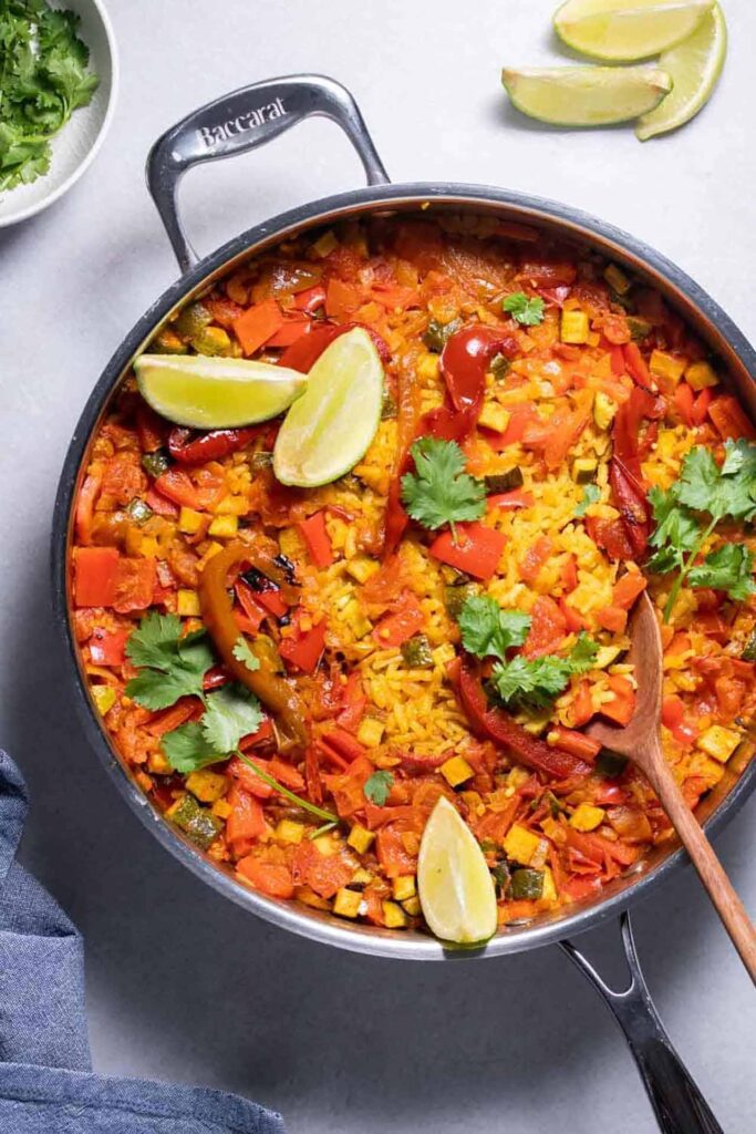 A skillet filled with paella sitting on a table.