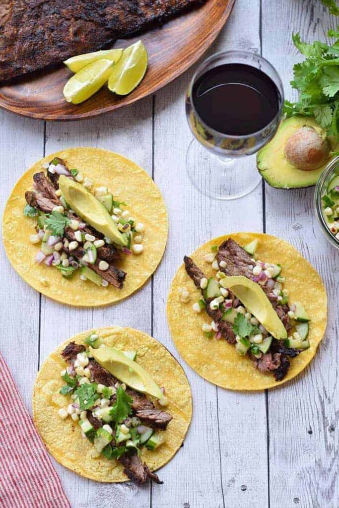 Three open tacos laying on a wood surface.