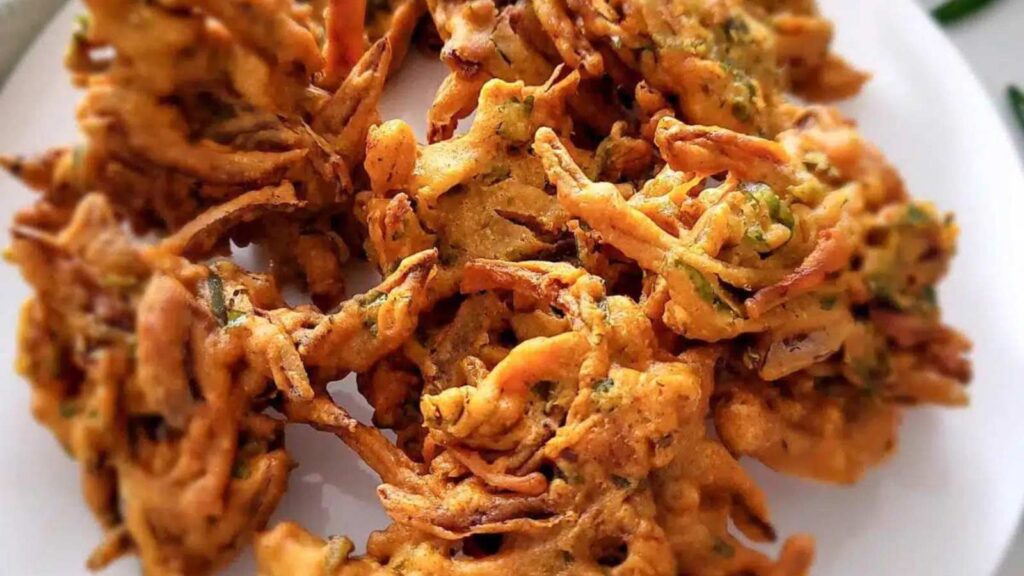 A white plate with onion bhaji on it.