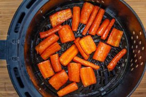 Air fried carrots in an air fryer basket.