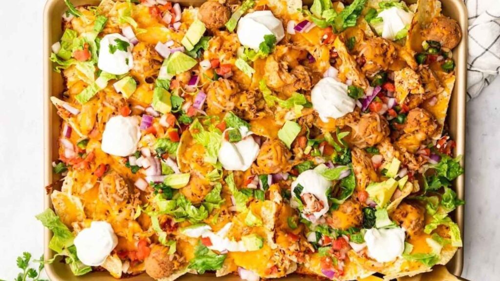 A sheet pan full of shredded chicken nachos.