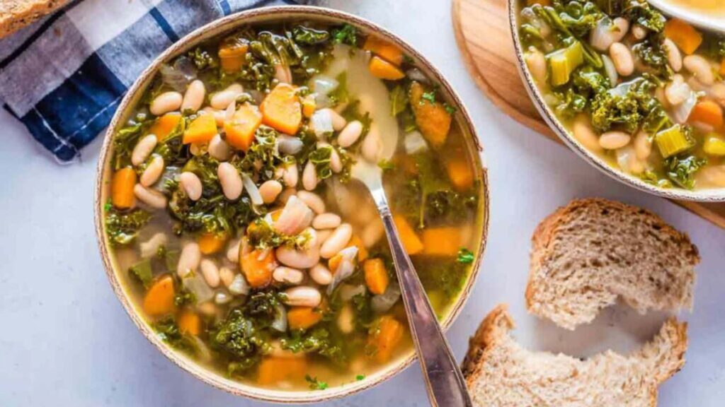 An overhead view of a bowl filled with Tuscan bean soup with kale.