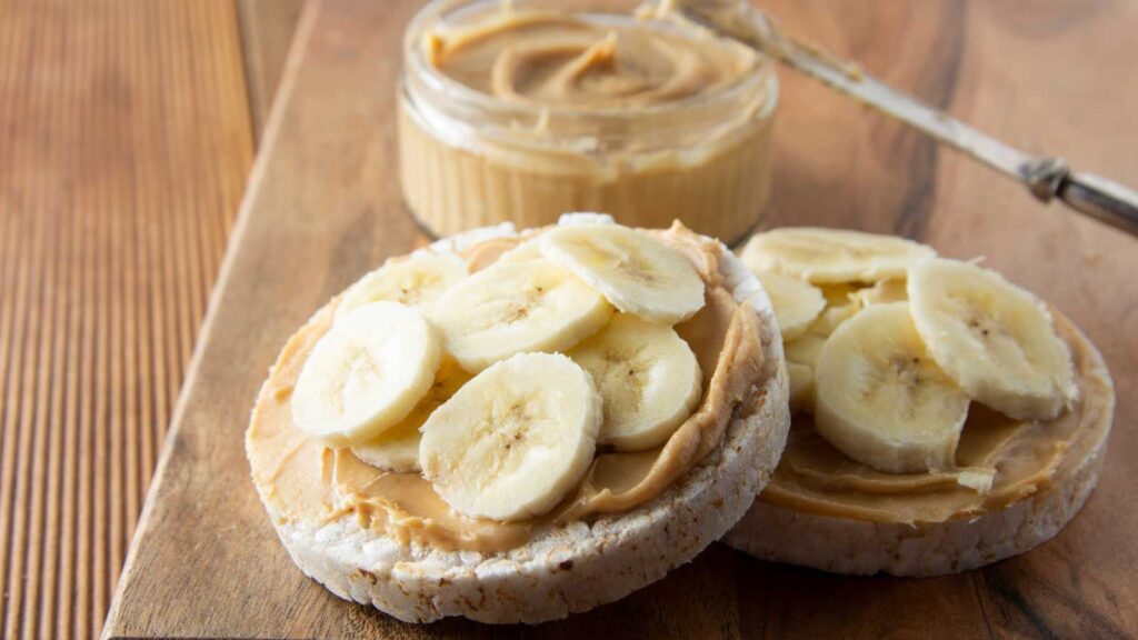 Two rice crackers with peanut butter and sliced bananas on them.