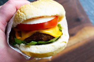 A hand holds an Air Fryer Turkey Burger wrapped in parchment.