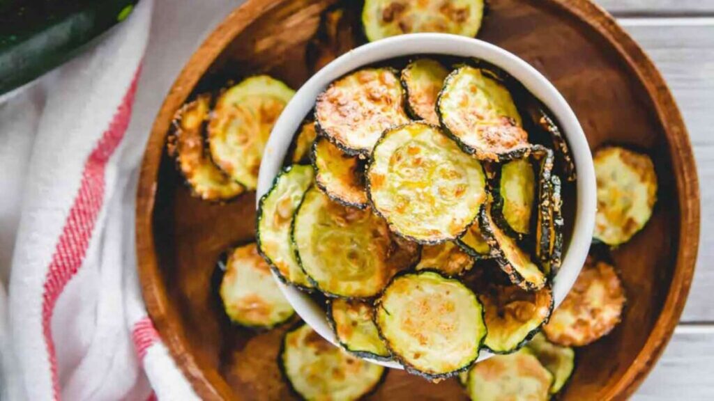 An overhead view of a bowl filled with air fryer zucchini chips.