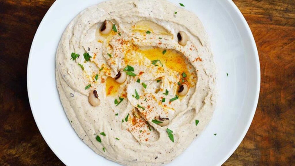 Horizontal overhead view looking down into a bowl filled with Black Eyed Pea Hummus.