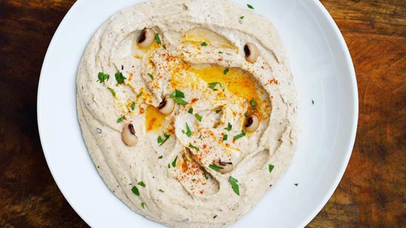 Horizontal overhead view looking down into a bowl filled with Black Eyed Pea Hummus.