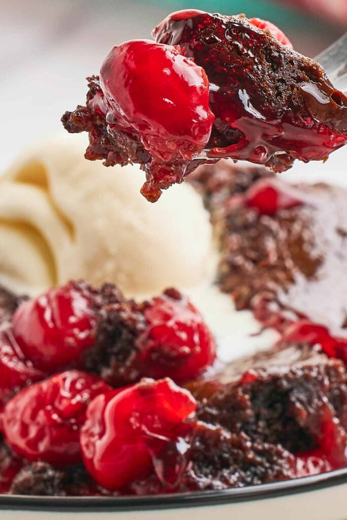 A closeup of a forkful of black forest dump cake.