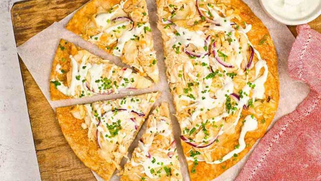 An overhead view of a half-sized buffalo chicken pizza.