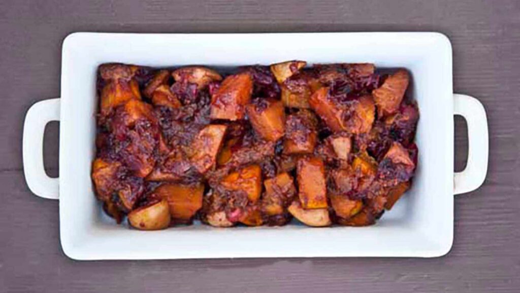 A white casserole dish filled with cranberry butternut bake.