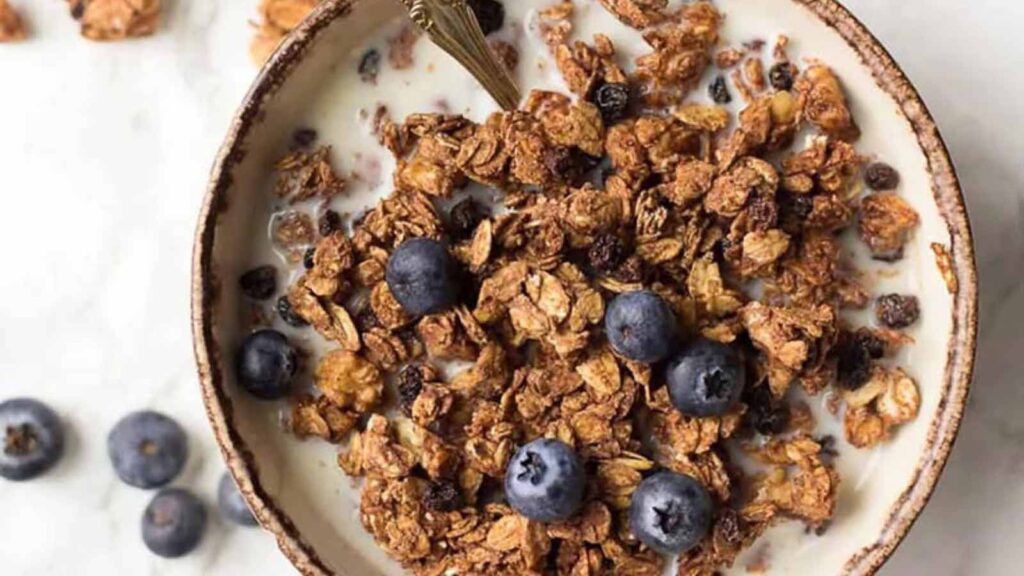 An overhead view of a bowl filled with milk and Vegan Granola With Tahini And Maple Syrup.