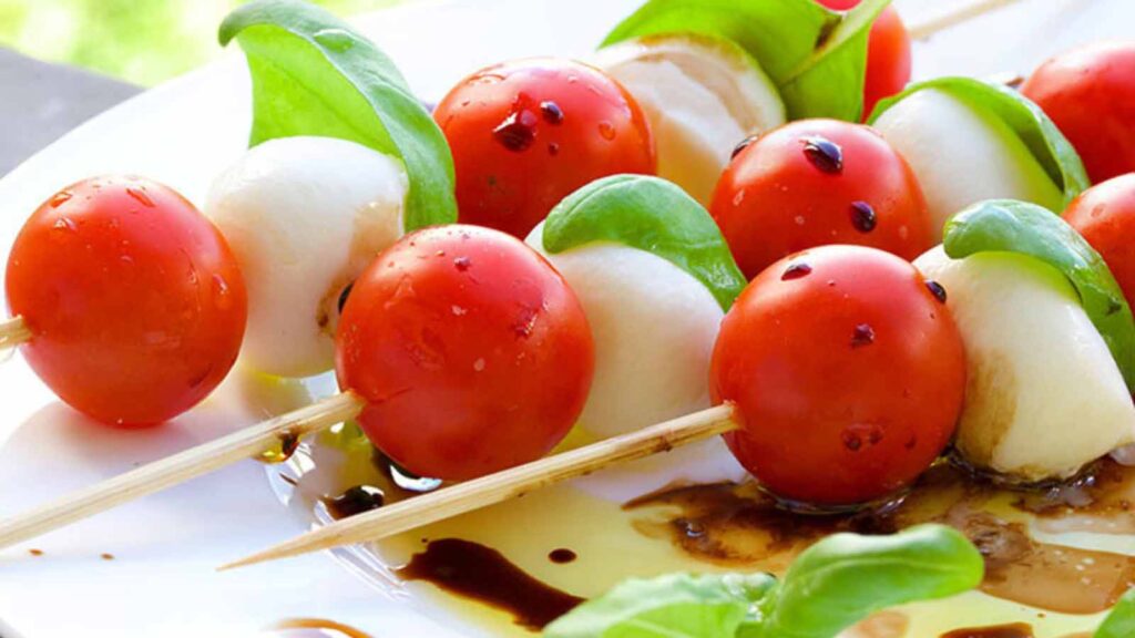 Caprese skewers on a white platter.