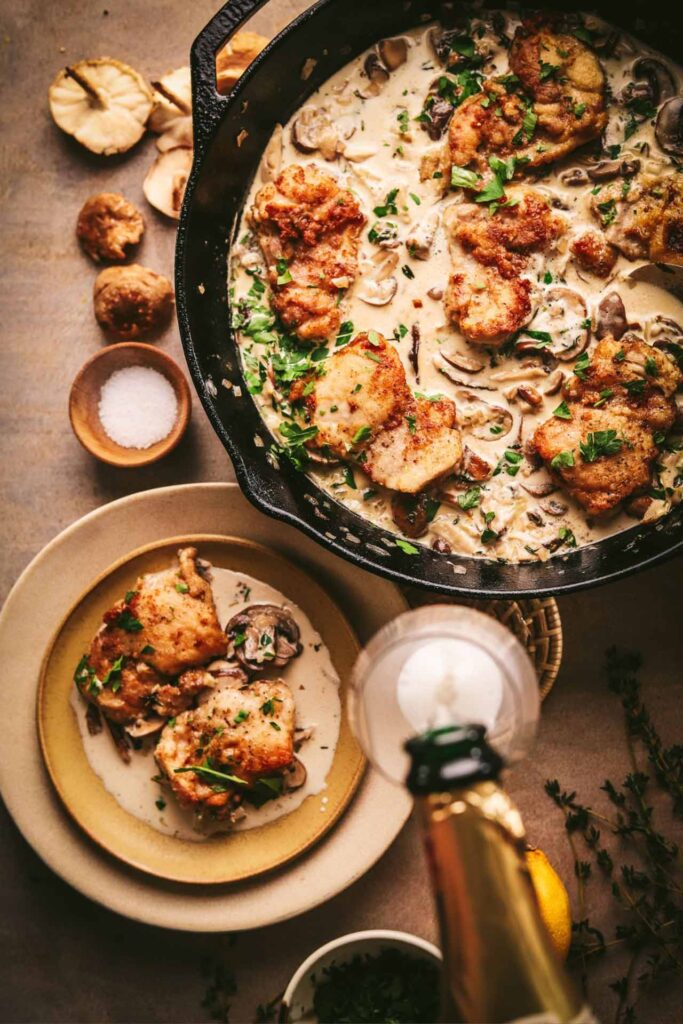 Champagne chicken served from a cast iron pot, sitting on a table.
