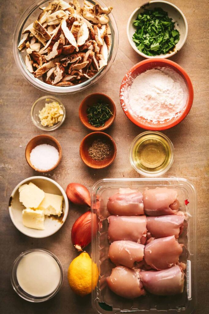 Champagne chicken recipe ingredients gathered on a wood surface.