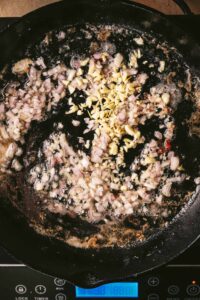 Onions and garlic saut&eacute;ing in a cast iron pot.