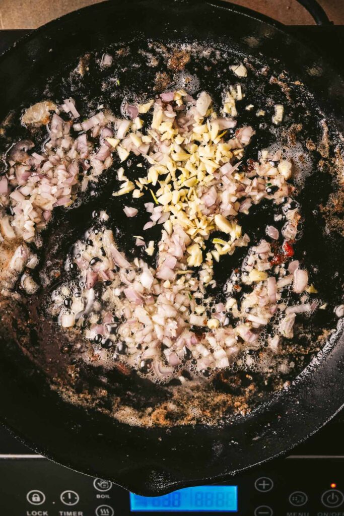 Onions and garlic saut&eacute;ing in a cast iron pot.