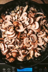 Saut&eacute;ing sliced mushroom with onions and garlic.