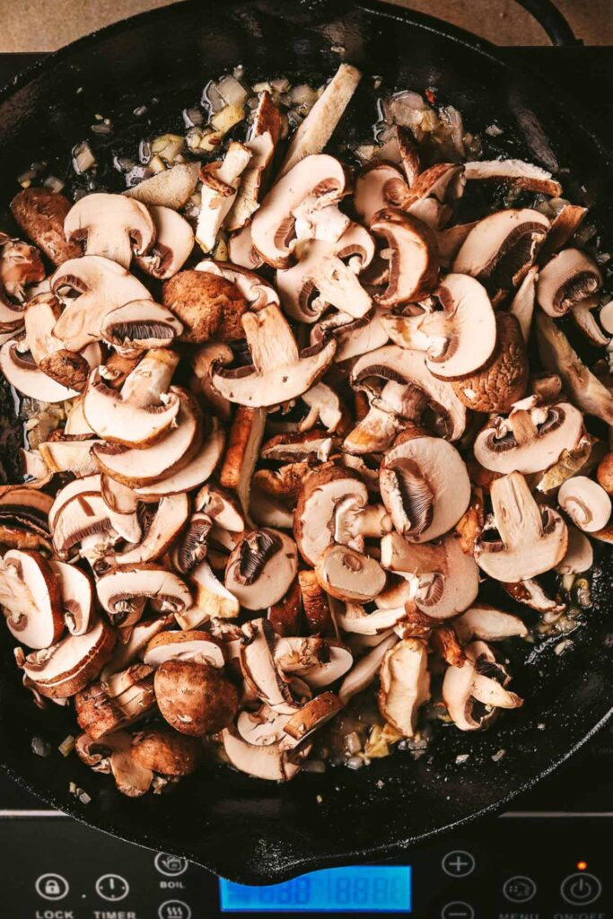 Saut&eacute;ing sliced mushroom with onions and garlic.