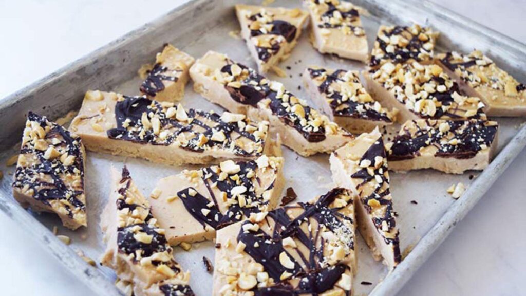 Just-cut Chocolate Peanut Butter Frozen Yogurt Bark pieces on a sheet pan.