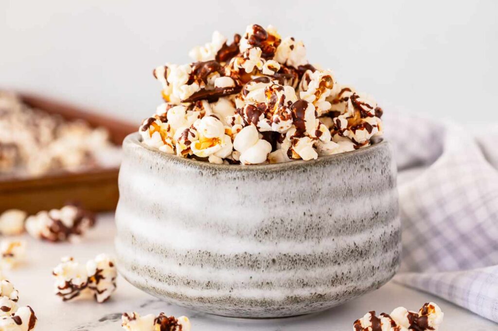 A gray ceramic bowl filled with Chocolate Popcorn.