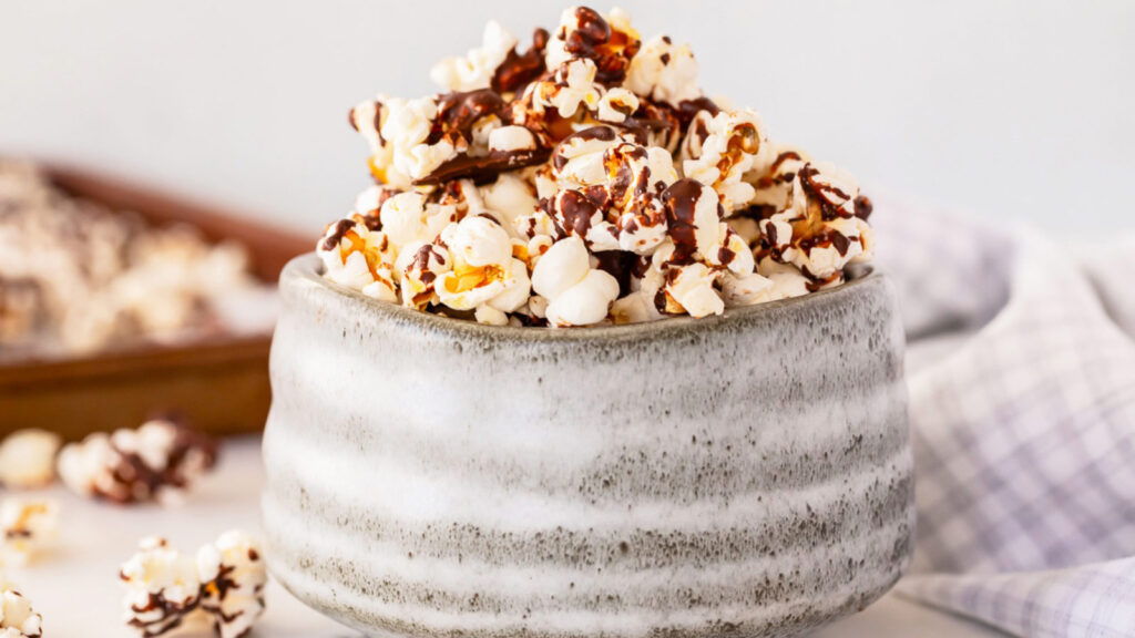 A side view of a gray bowl filled with Chocolate Popcorn.