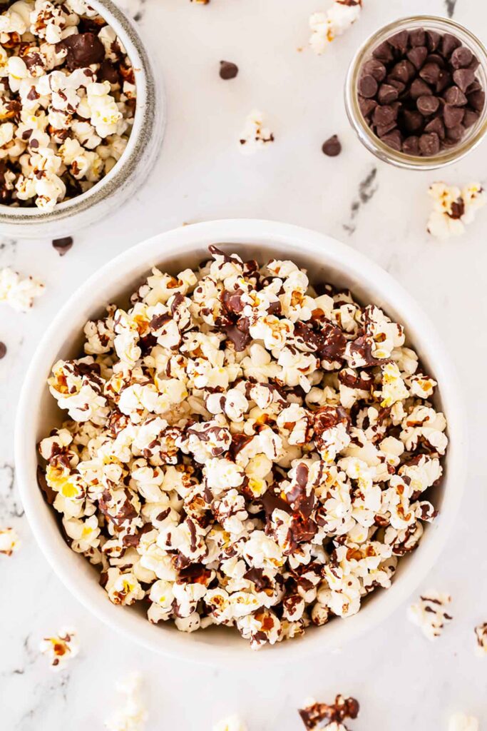 An overhead view of a white bowl filled with Chocolate Popcorn.