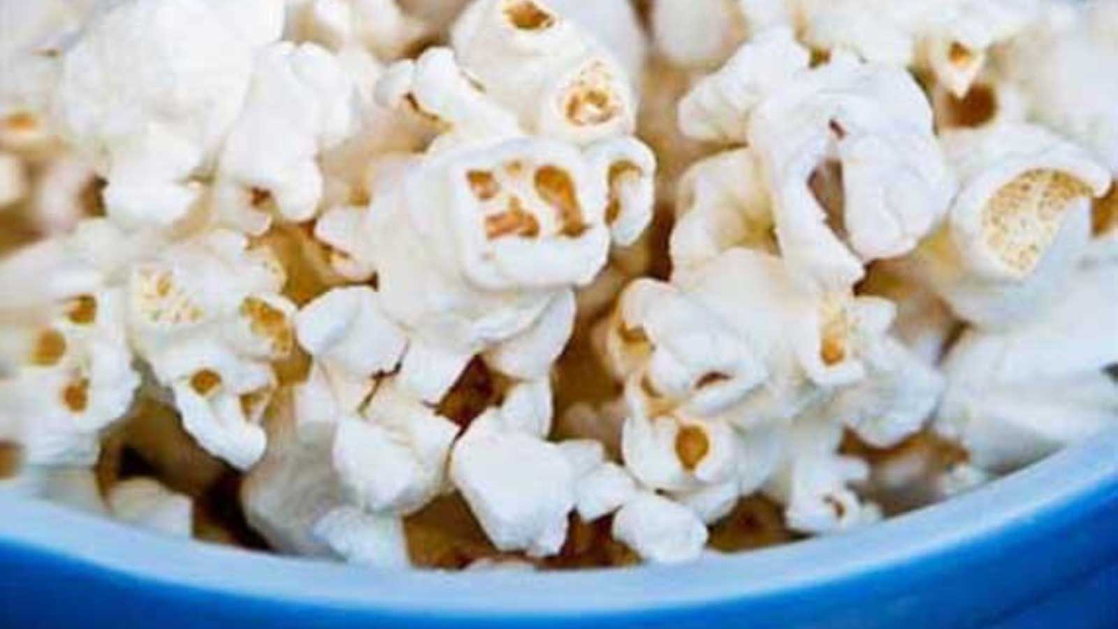 Blue bowl filled with coconut oil popcorn.