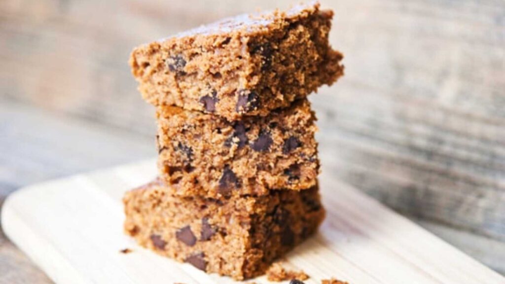 Three stacked slices of Cinnamon Chocolate Chip Crazy Cake on a cutting board.