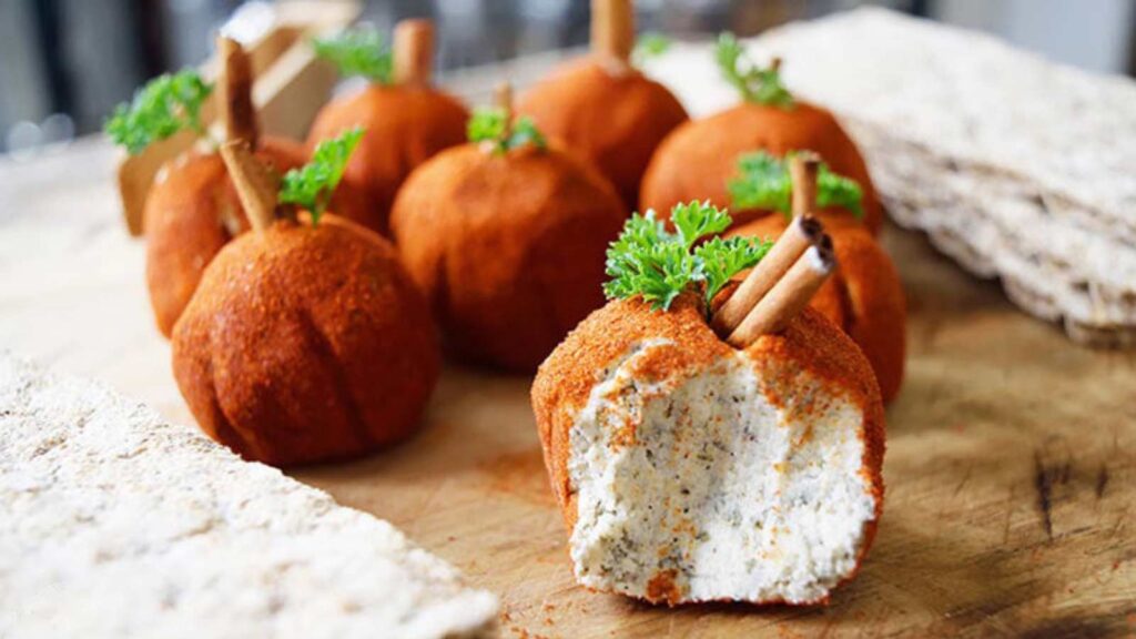 A group of Cream Cheese Balls on a cutting board between some crackers.