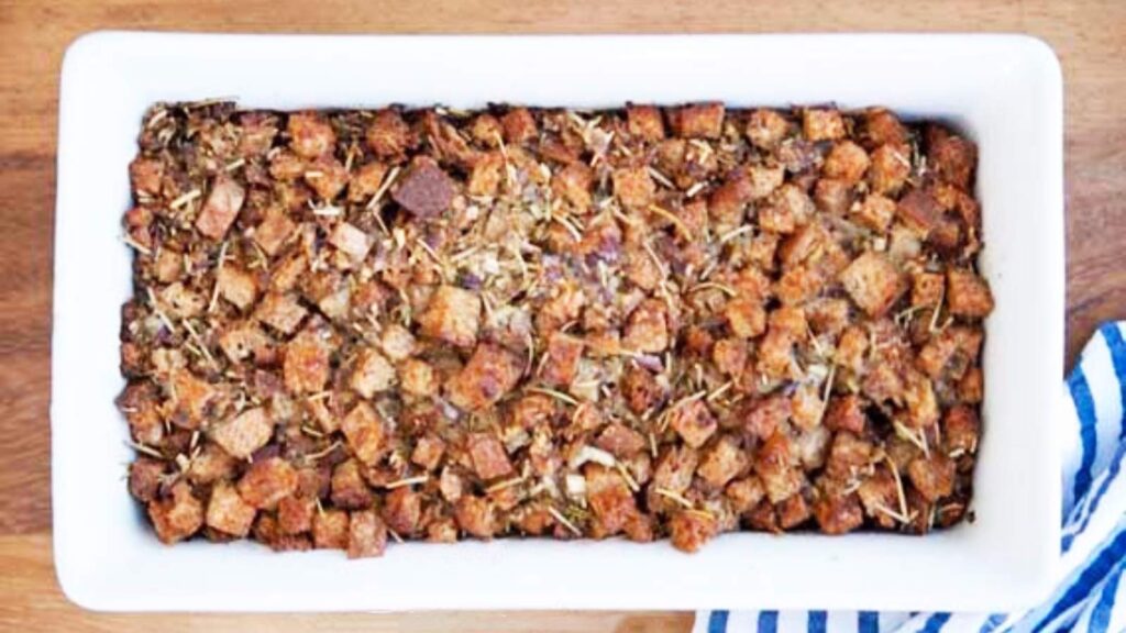 An overhead view of crouton stuffing in a white casserole dish.