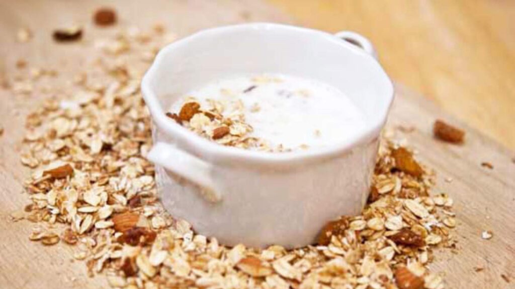 A small white bowl filled with milk and cold cereal.