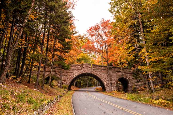 A bridge in Maine with fall foliage.