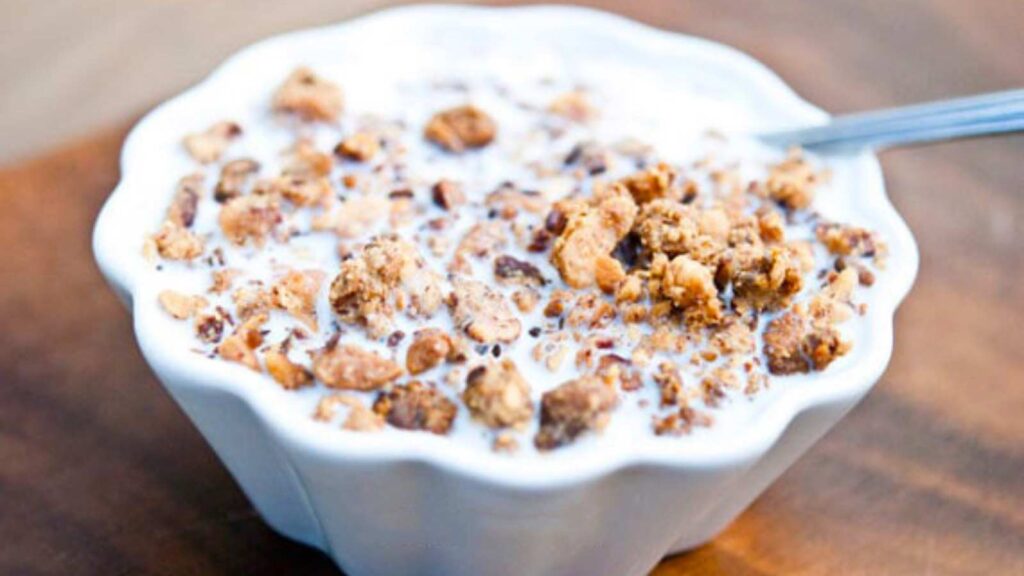 A white bowl filled with Homemade Grape Nuts Cereal and milk.