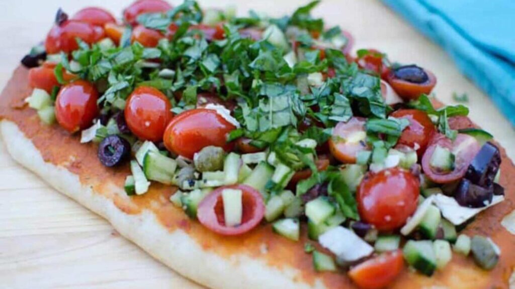 A grilled flatbread laying on a cutting board.