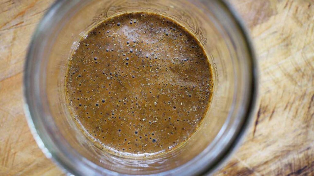 An overhead view of a canning jar partially filled with healthy balsamic vinaigrette.