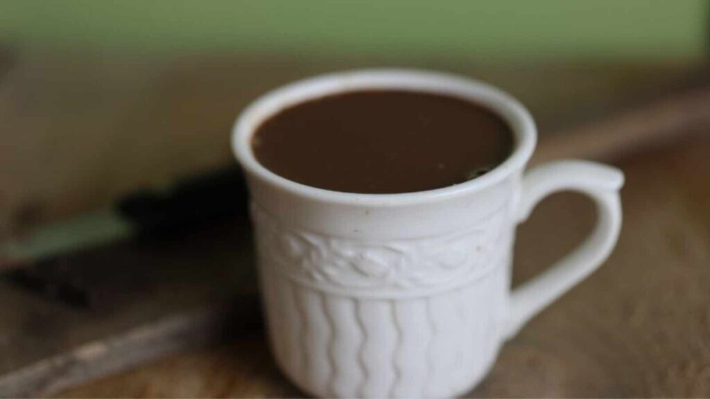 A single mug on hot chocolate on a wood surface.