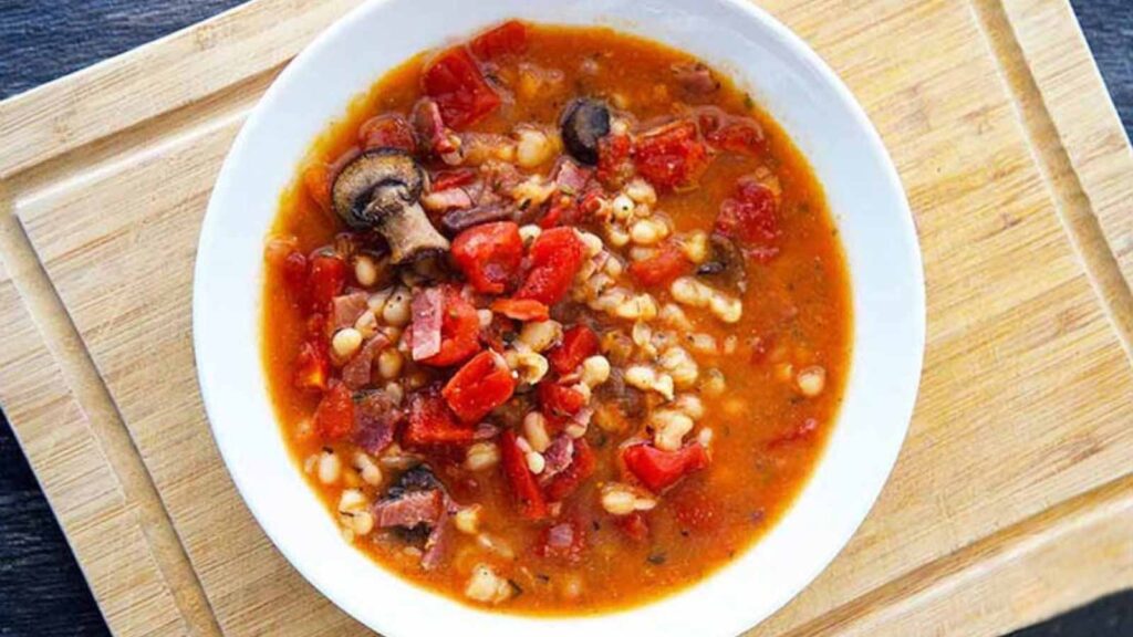 An overhead view of a white bowl filled with Italian navy bean soup.