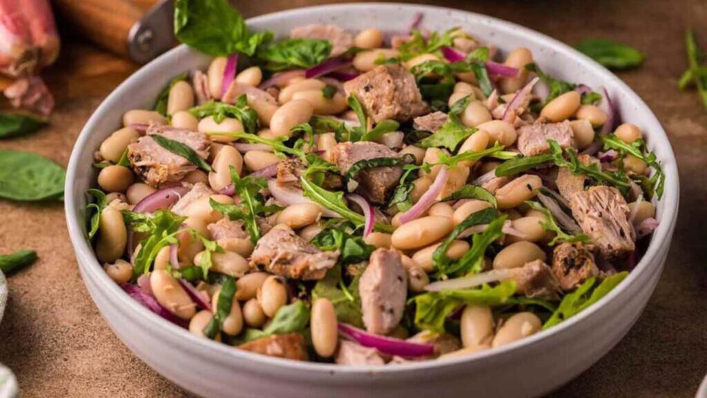 A white bowl filled with Italian tuna white bean salad.
