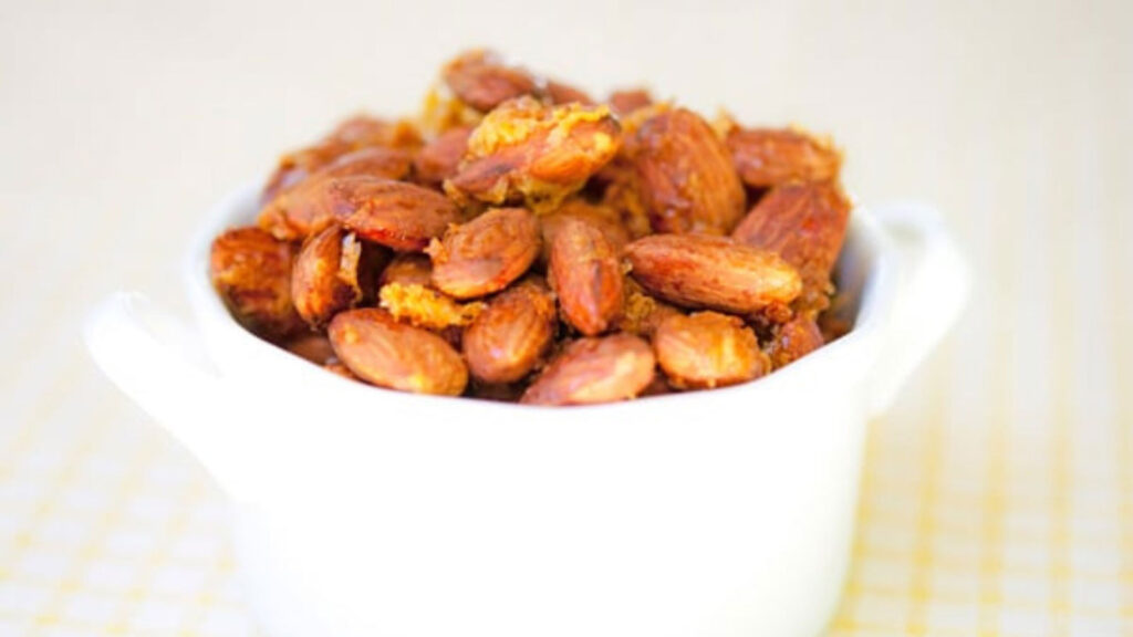 A white bowl filled with Lemon & Honey Almonds.