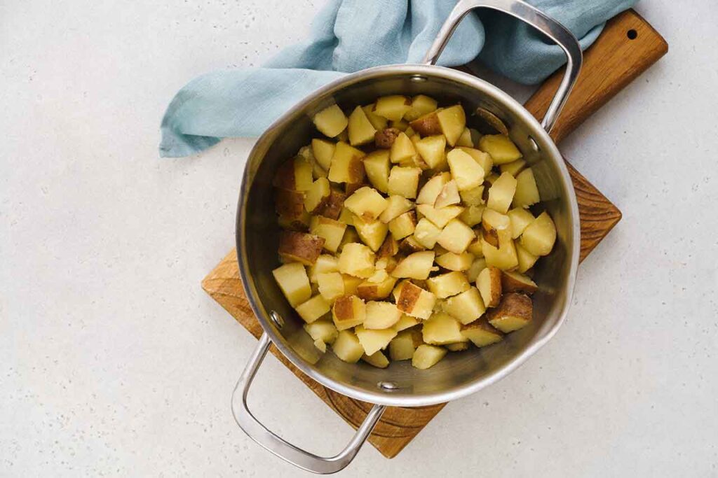 Cut and cooked potatoes in a pot.