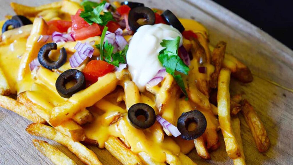 Nacho fries on a wood cutting board.