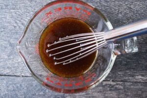 Vinaigrette whisked together in a glass measuring cup.