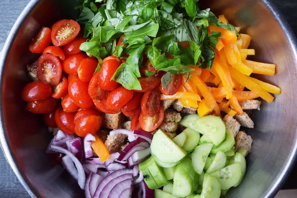 All the Panzanella Recipe ingredients in a big metal mixing bowl.