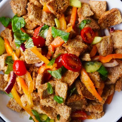 An overhead view of a white plate filled with Panzanella.