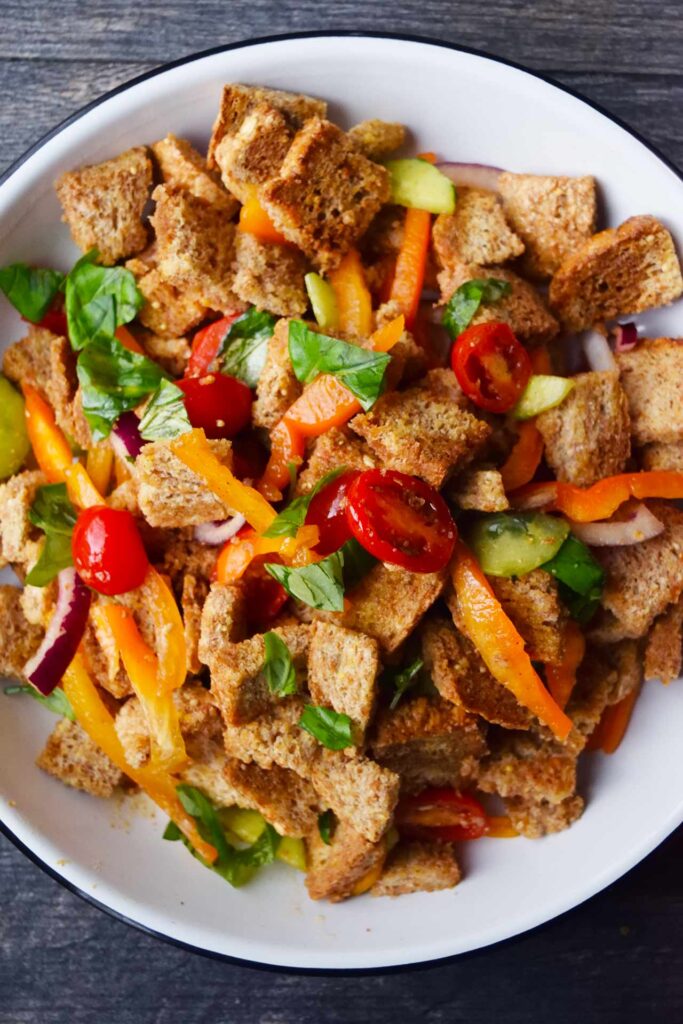 An overhead view of a white plate filled with Panzanella.