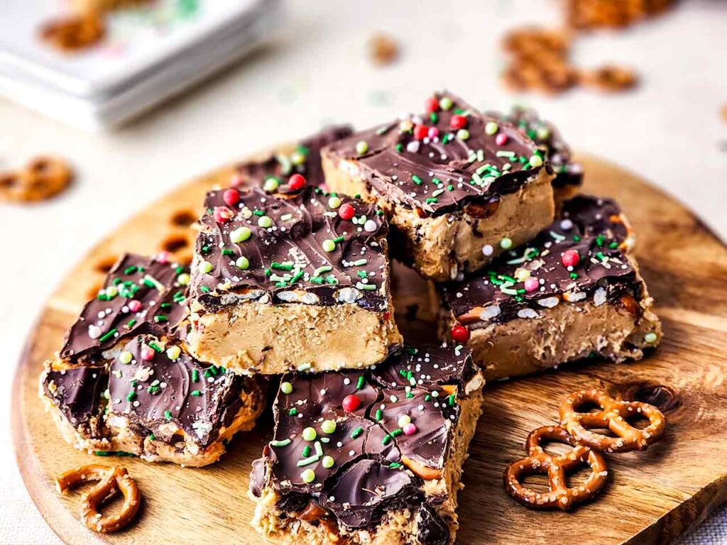 Peanut Butter Chocolate Bars, cut and stacked on a round, wood cutting board.