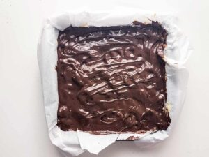 The melted chocolate spread evenly over the contents of the baking pan.